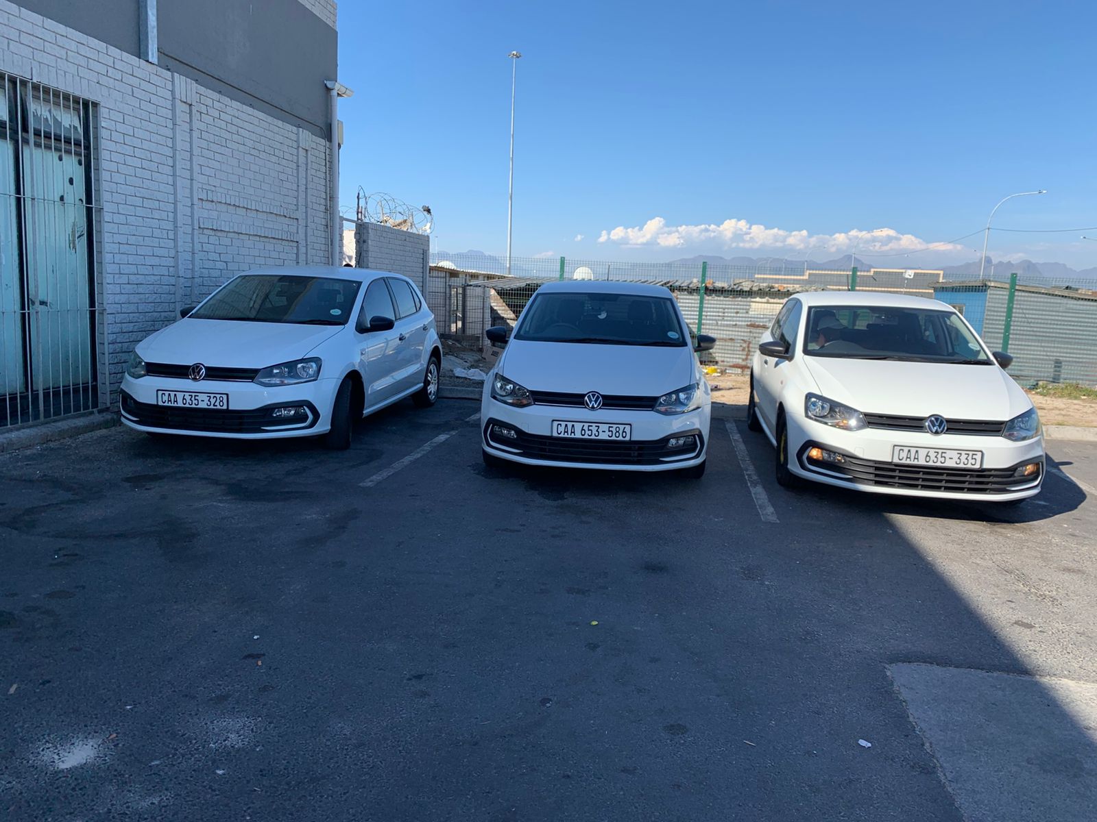 Three white Volkswagen Polo vehicles for self-drive rental